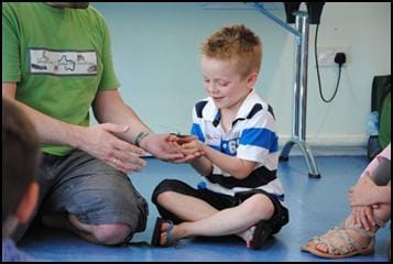 Child holding an insect