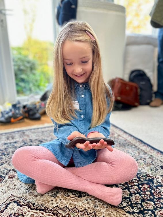 Child handling a giant millipede